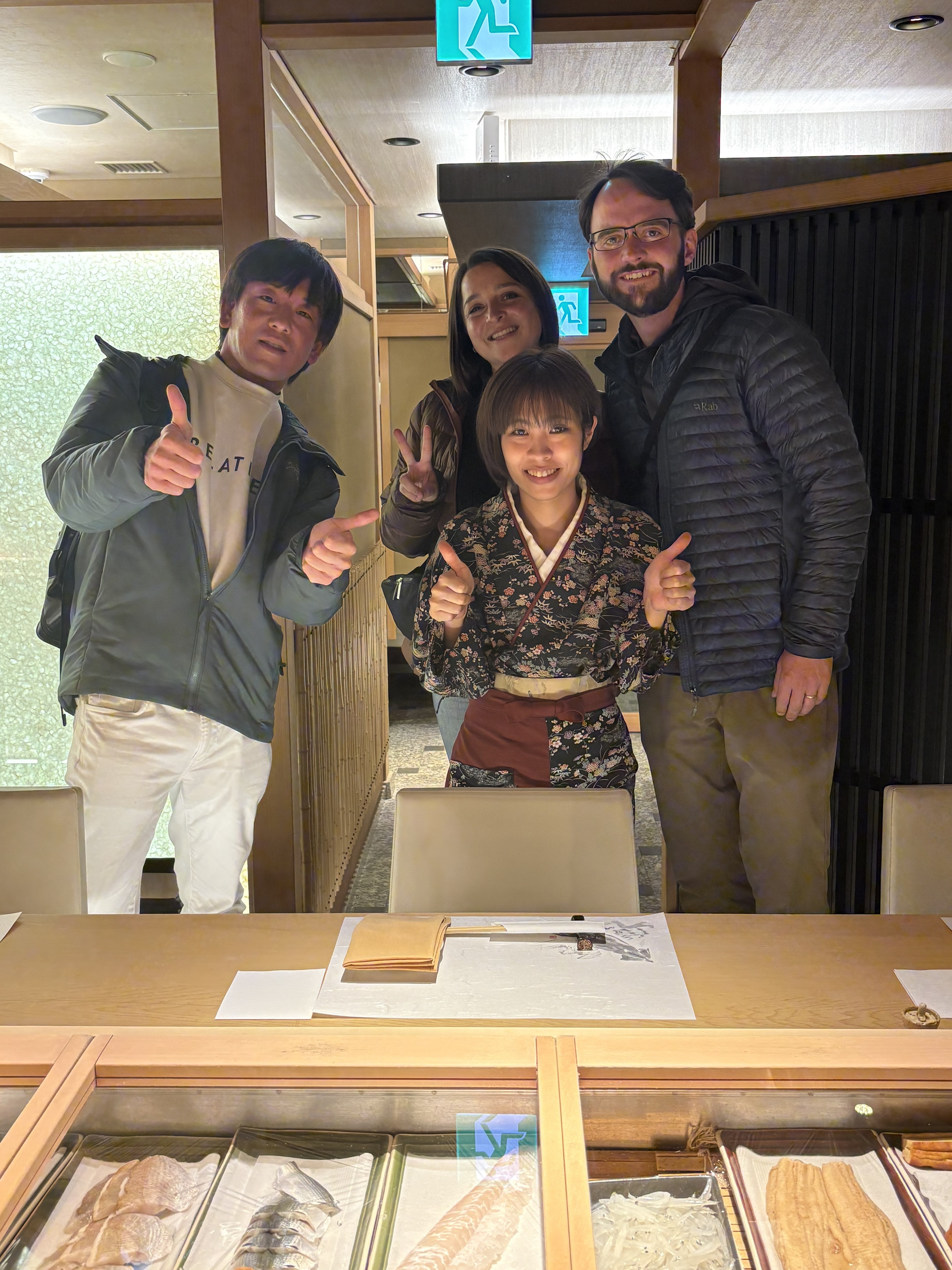 Guests with kimono-clad host at a premium sushi counter